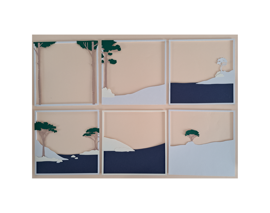Six paper prototype layers of a snowy landscape laid out side by side to test depth and fit