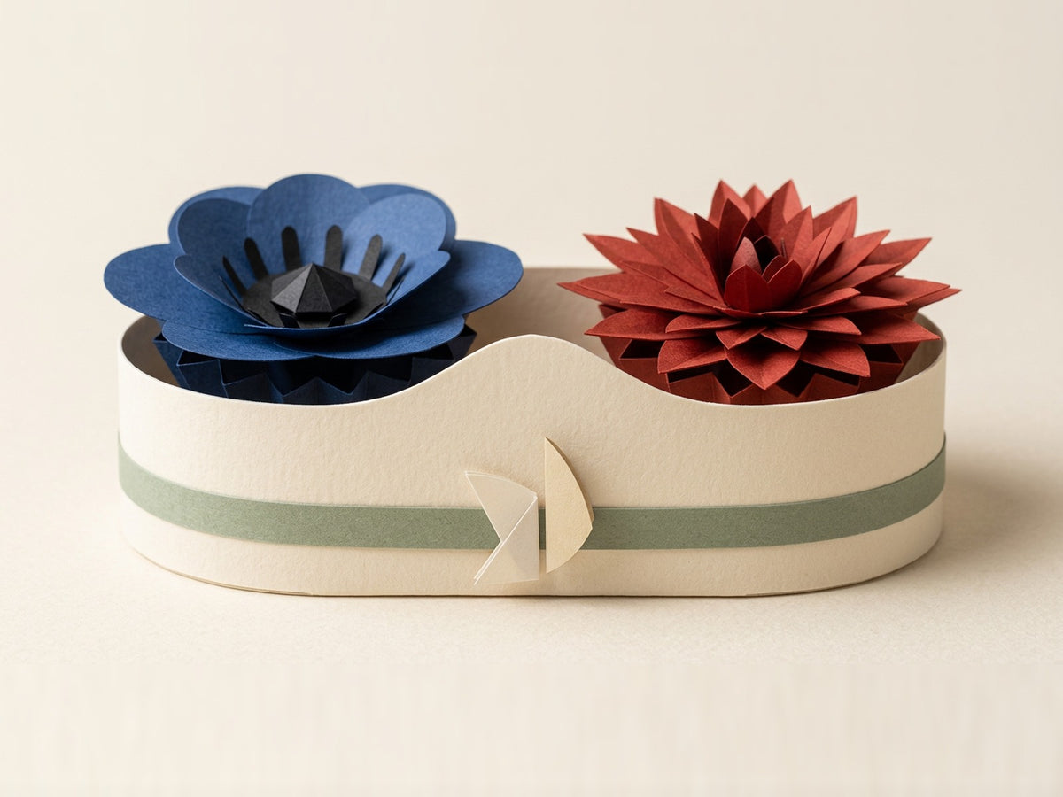 Papierblumen-Strauß-Box mit Anemone und Dahlia, gefalteter Papiervogel auf dem salbeigrünen Band