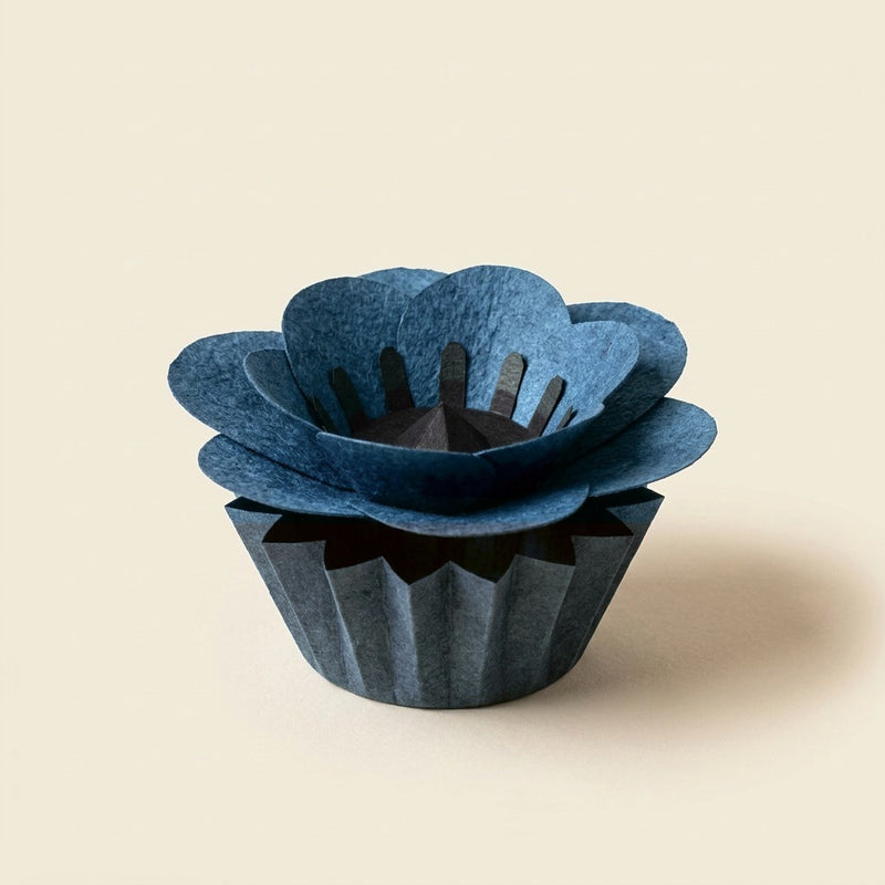 Forever Paper Flower Anemone in indigo blue on its tonal pleated paper cup, three-quarter view