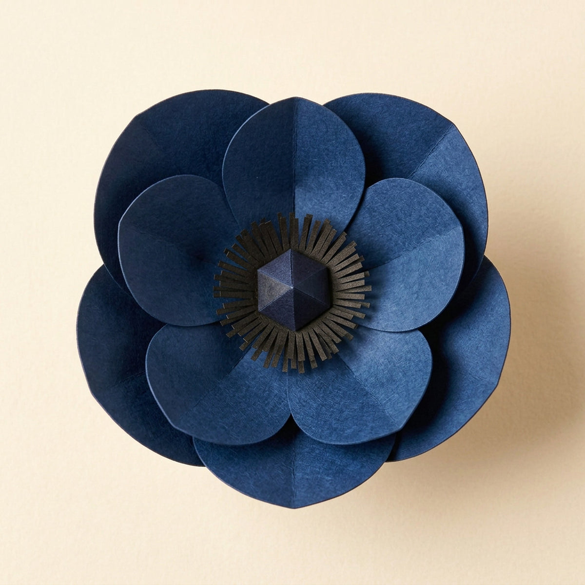 [CONCEPT PLACEHOLDER] Anemone paper flower in indigo on its pleated paper cup, top-down view (AI concept image, not the final product)