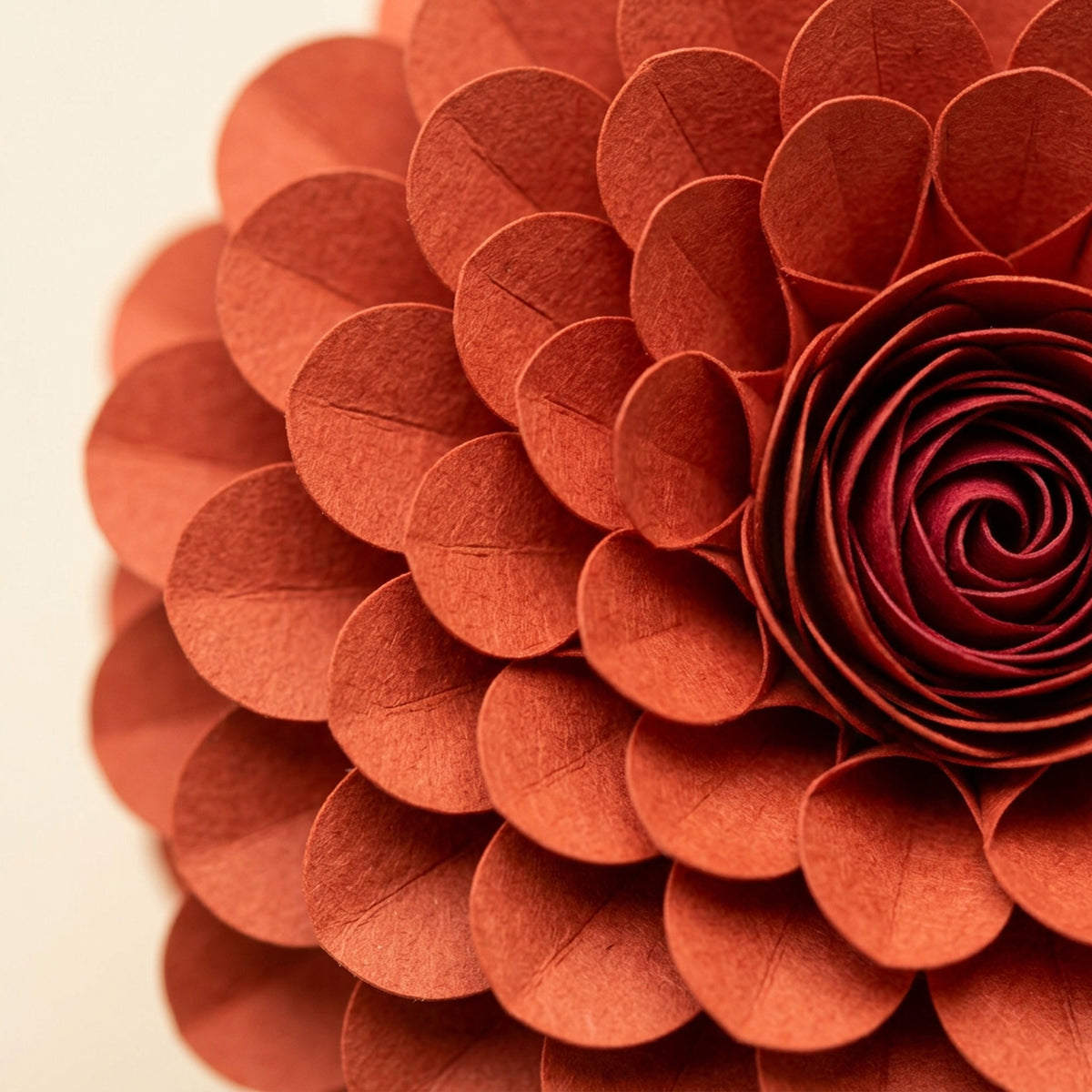 [CONCEPT PLACEHOLDER] Dahlia paper flower in sumac red on its pleated paper cup, close-up of the folded paper petals (AI concept image, not the final product)