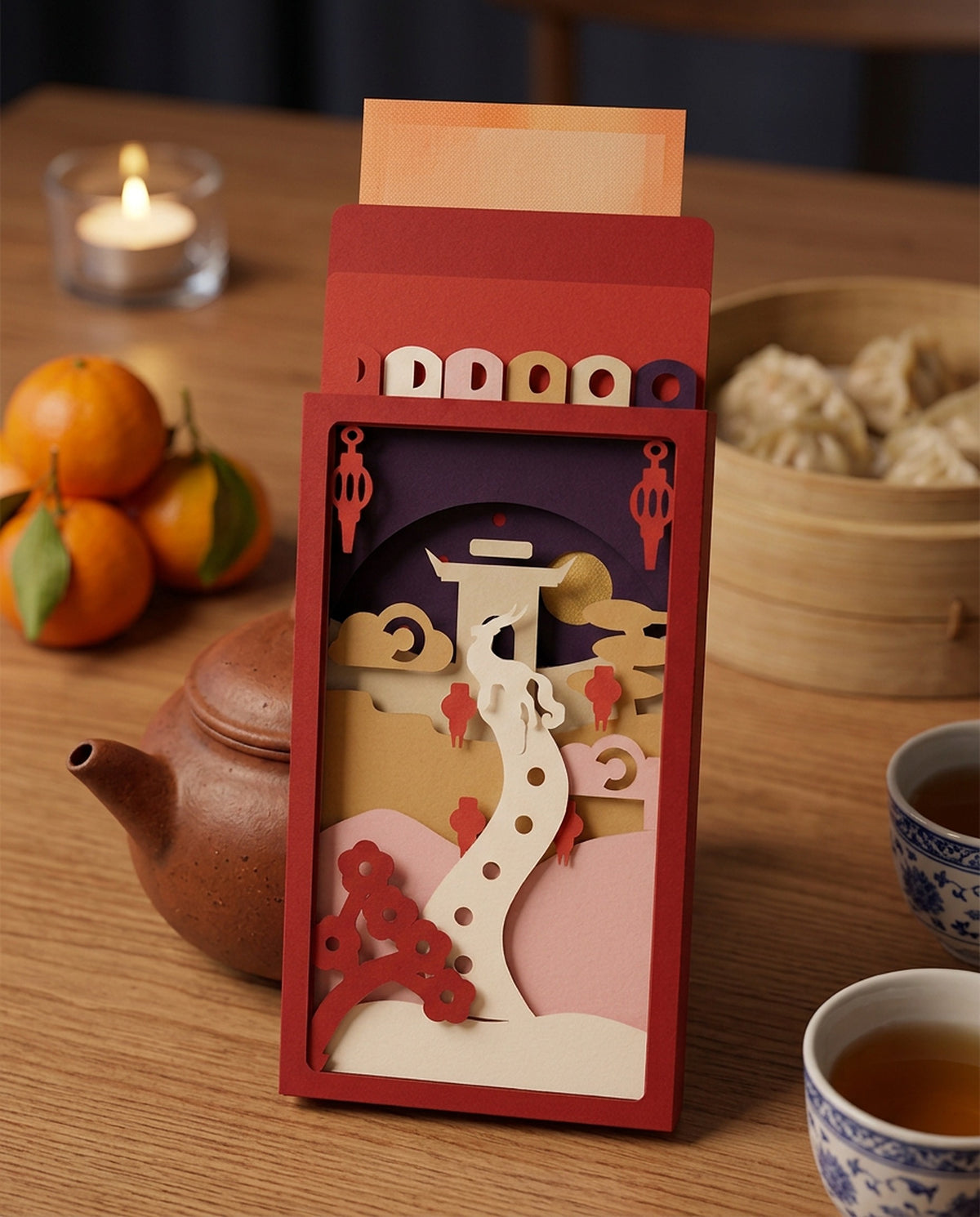 The opened Year of the Goat paper-art hongbao propped against a teapot on a Chinese New Year dinner table