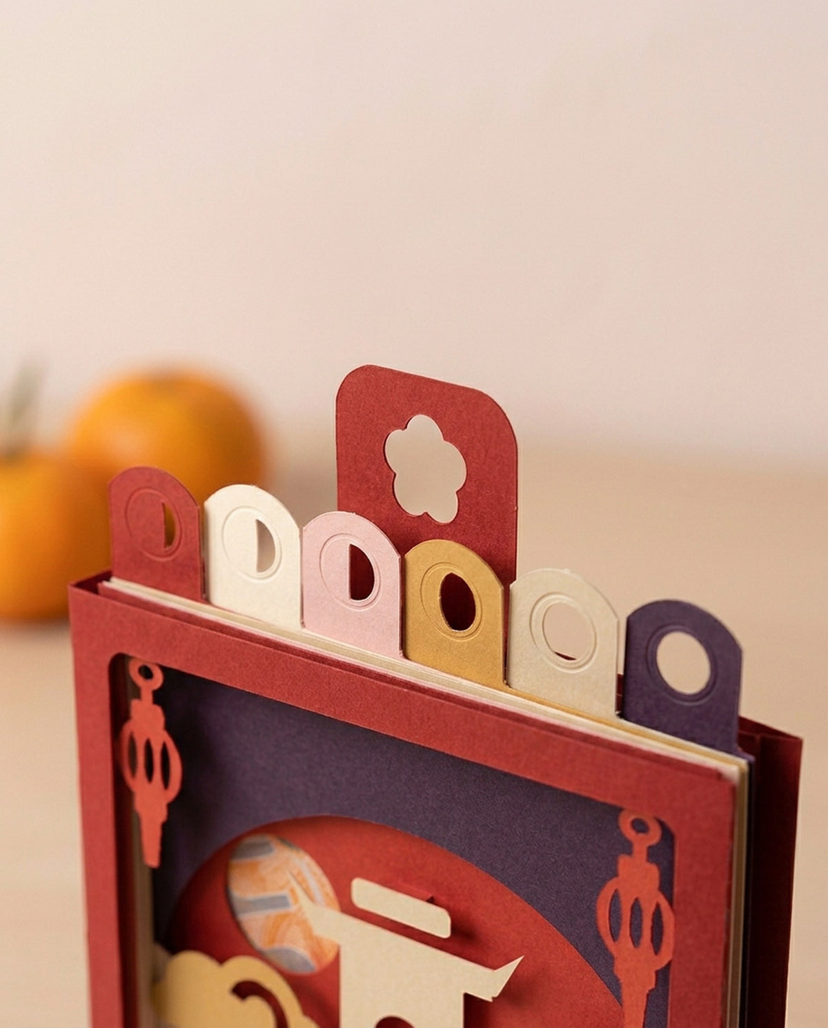 Close-up of the six waxing-moon layer tabs and cut paper edges of the Year of the Goat Pocket Story